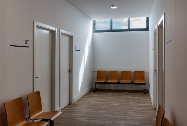 Pasillo reformado de clínica médica moderna, con luz natural y zona de espera en Telde